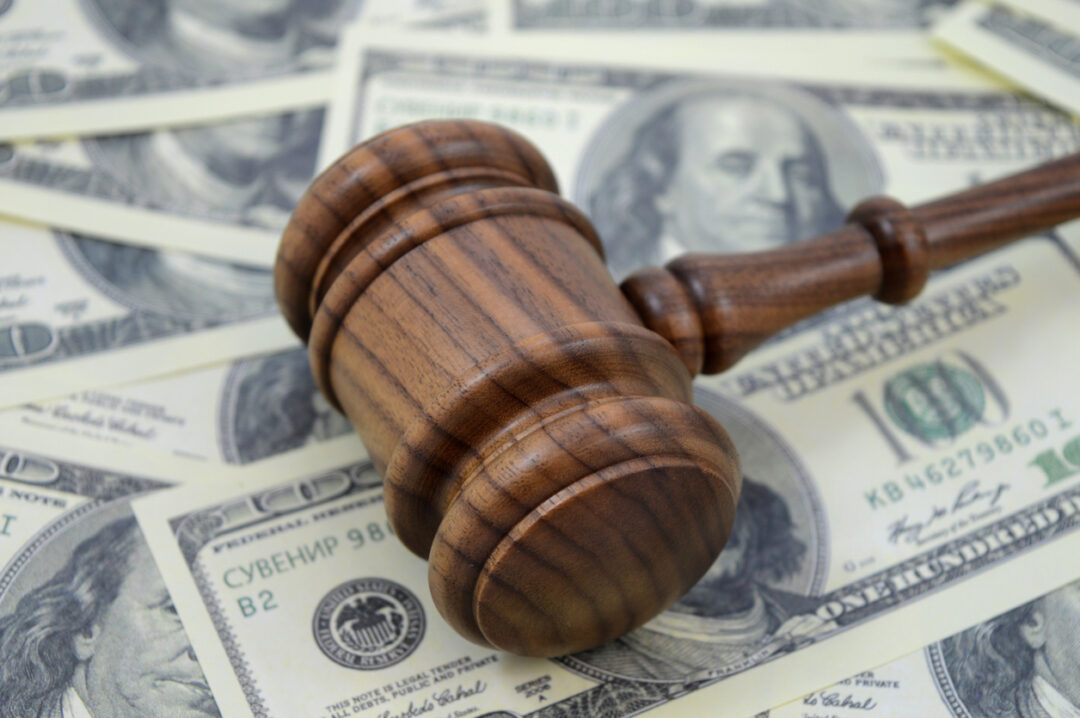 A judge’s gavel rests on a pile of money that a business has to pay after making common business mistakes