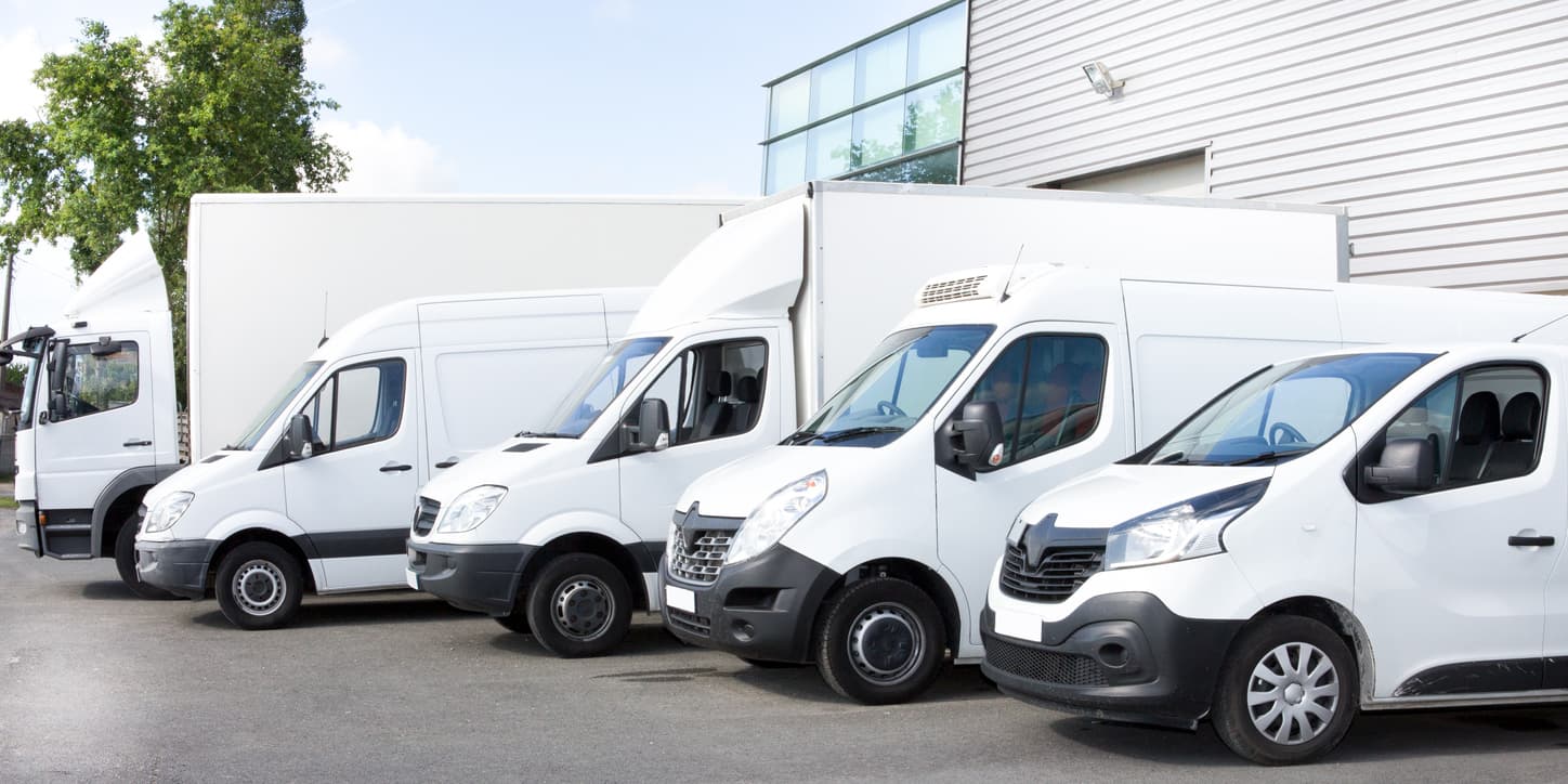 Commercial vans in a parking lot subject to commercial auto insurance exclusions